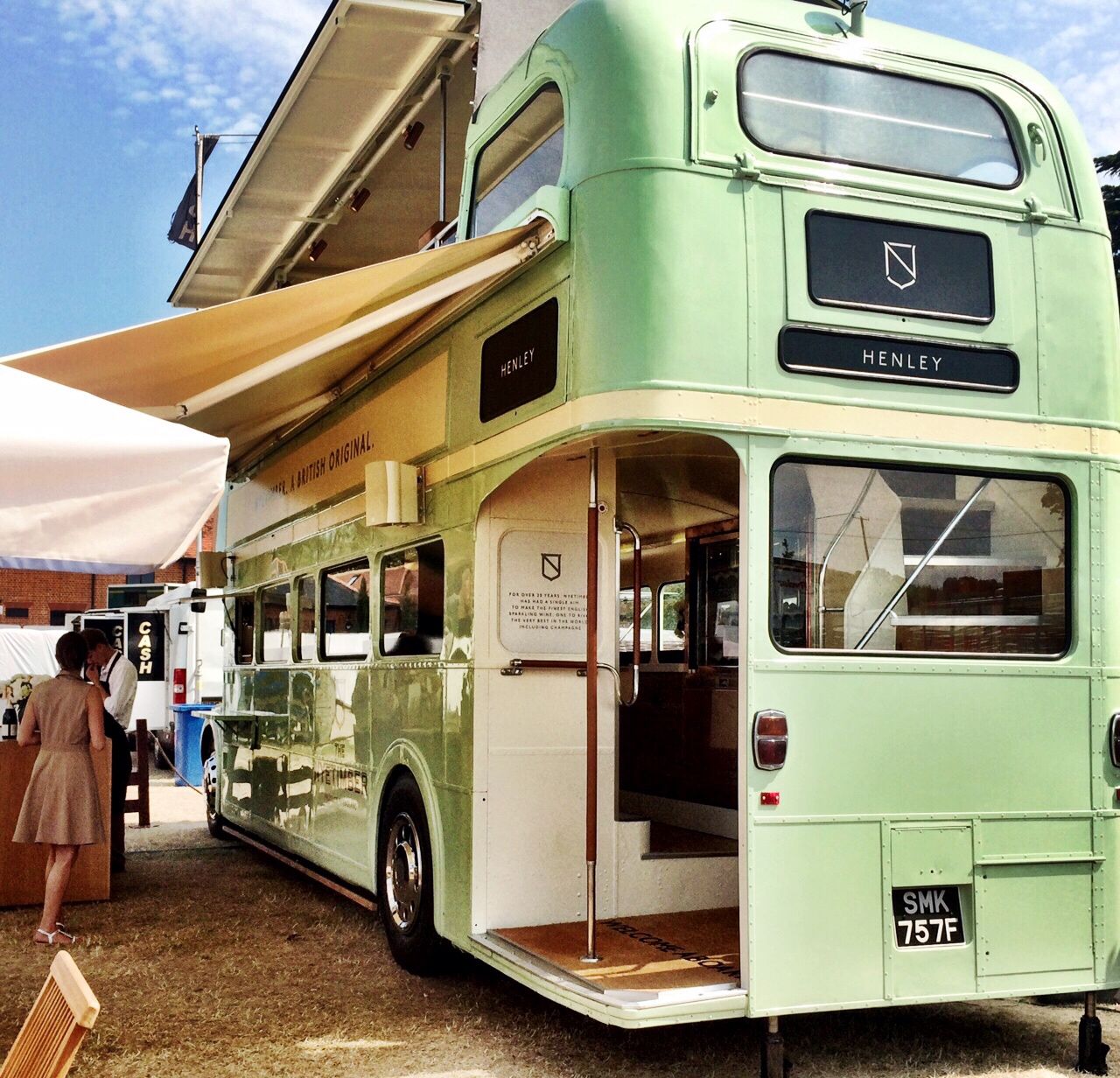 the back of a green vintage open top bus, with a pull out awning