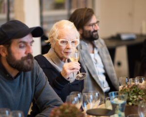 vivienne westwood sat between two men drinking wine