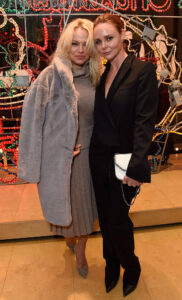 pamela anderson and stella mccartney pictured in front of christmas decorations