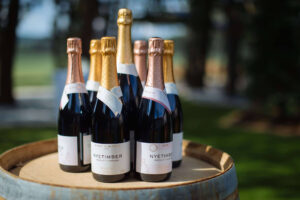 multiple wine bottles presented on top of a barrel