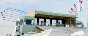 open top bus, with planes flying in formation behind