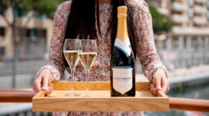 woman holding a tray, presenting wine bottle and two wine glasses