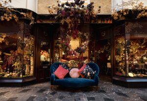 floral boutique store front and window display with blue sofa